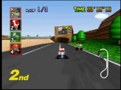 Toad sur la piste Luigi's Raceway, où sa course est retransmise sur grand écran ! (Mario Kart 64)
