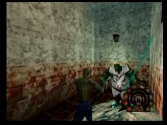 Glups, mauvaise suprise dans cette cellule ensanglantée de l'asile du jeu Shadow Man sur N64. Je vous conseille de courir car cet ennemi est coriace (Shadow Man)