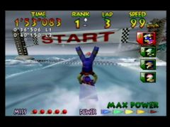 Miles Jeter fait le poirier pour célébrer sa victoire à la course Marine Fortress du jeu Wave Race 64 sur Nintendo 64. Move on to the next round ! (Wave Race 64)